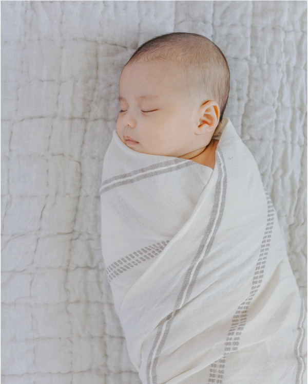 Baby wrapped in fair trade crafted swaddle